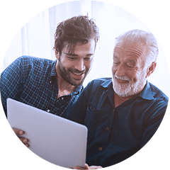 Grown up son and father using laptop together